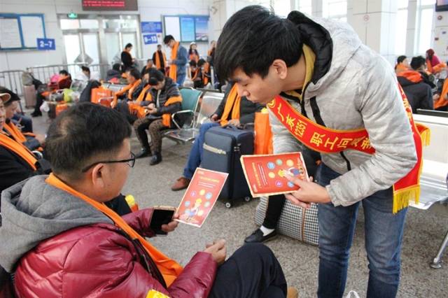 广东12351职工热线工作人员在高铁站为外来务工人员进行普法宣讲。省总工会供图
